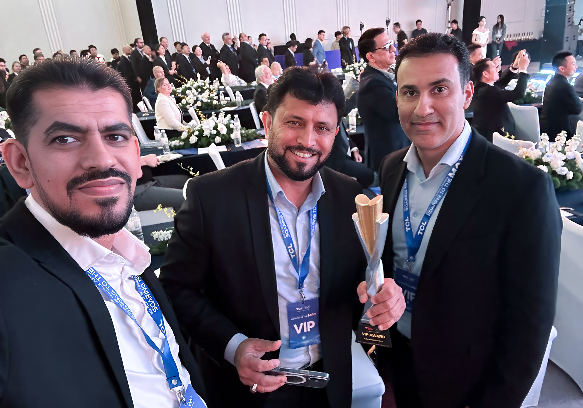 ALSALAM Electronics representatives at the TCL Global Conference 2026 in Chongqing, China, with one holding the TCL Global Excellence Award trophy.